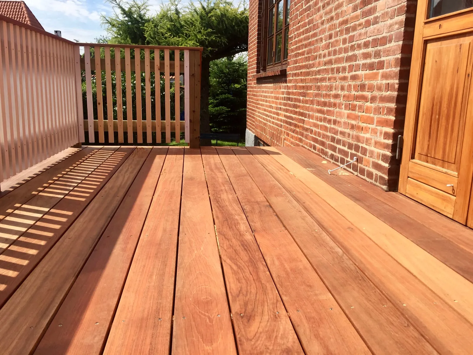 Hardwood-terrasse med slidset værn i solen
