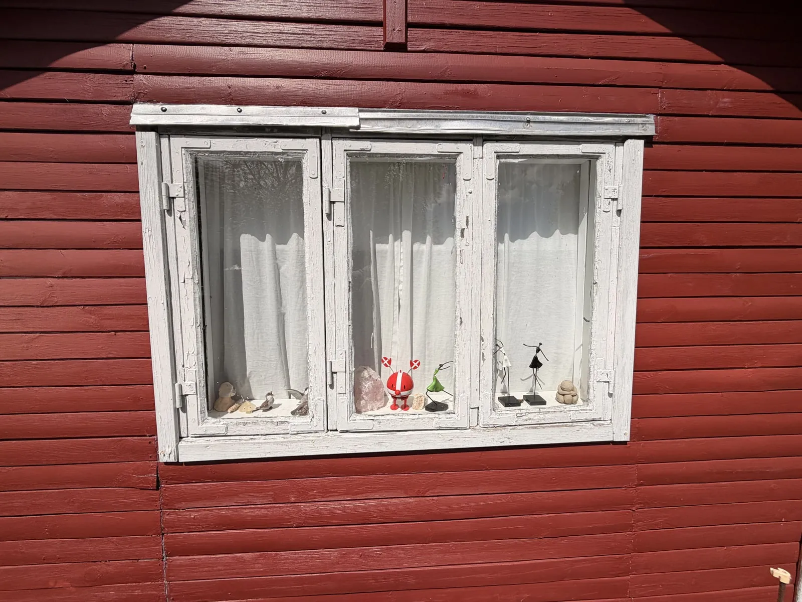 Gammelt trævindue med afskallet maling før udskiftning